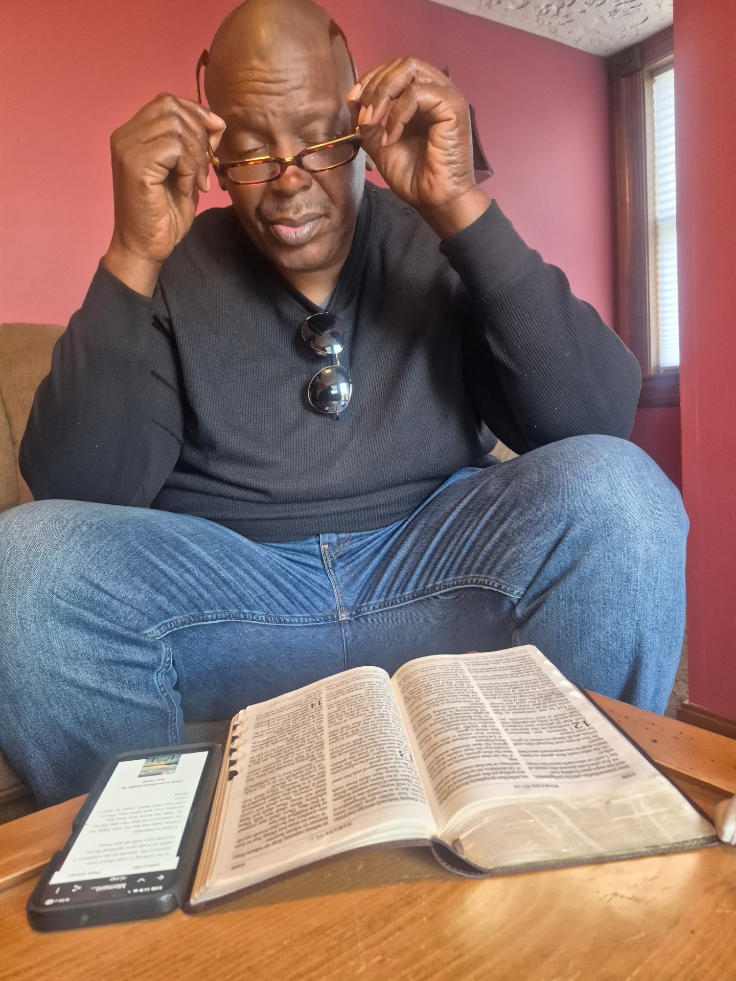 Hands holding an open Bible in soft sunlight